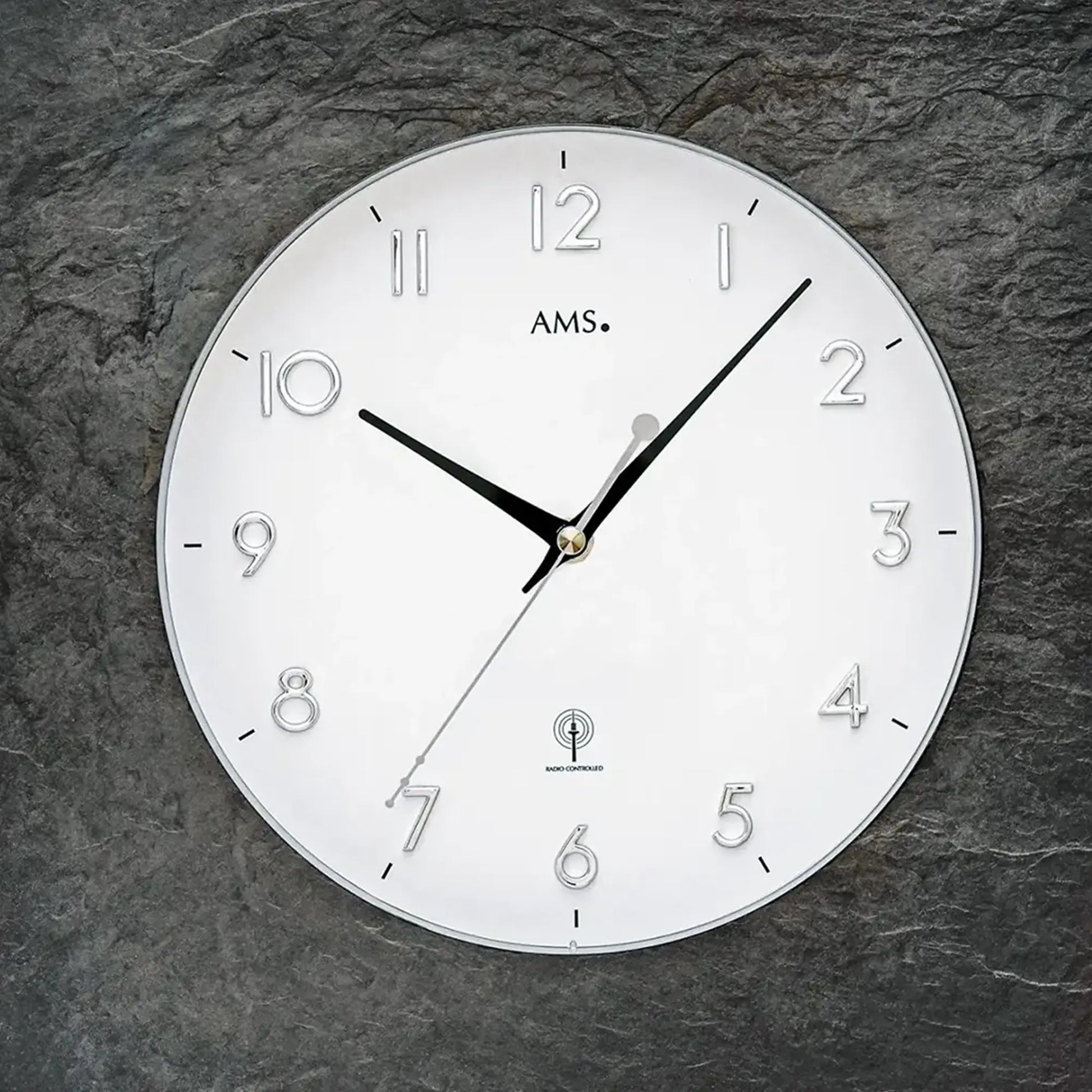 Nahansicht: runde Funk-Wanduhr mit naturschiefergrauem Rand und Mineralglas