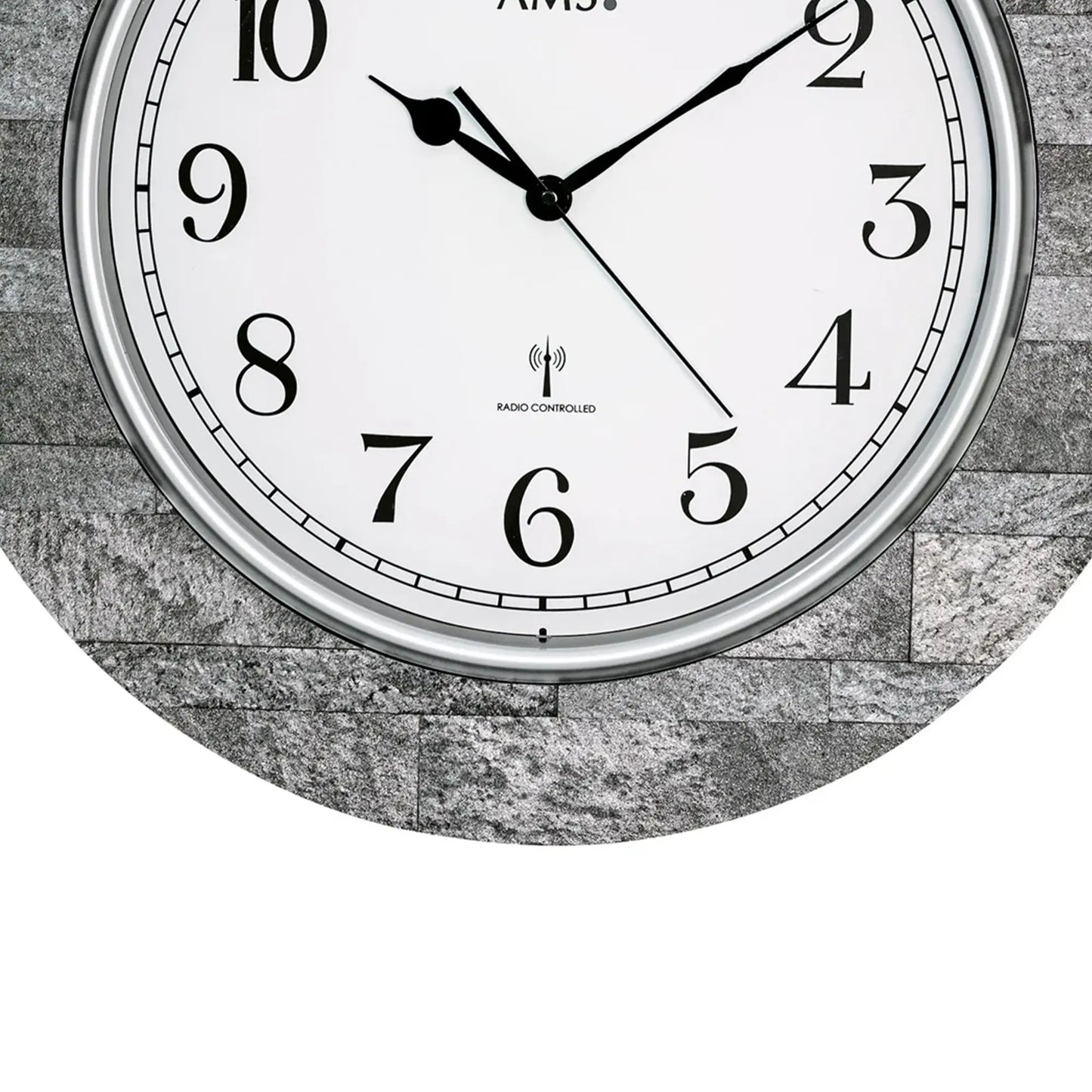 Nahaufnahme Wanduhr: weißes Ziffernblatt, schwarze Zeiger, „RADIO CONTROLLED“-Logo.