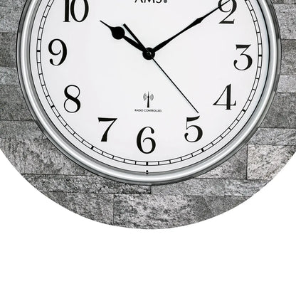 Nahaufnahme Wanduhr: weißes Ziffernblatt, schwarze Zeiger, „RADIO CONTROLLED“-Logo.