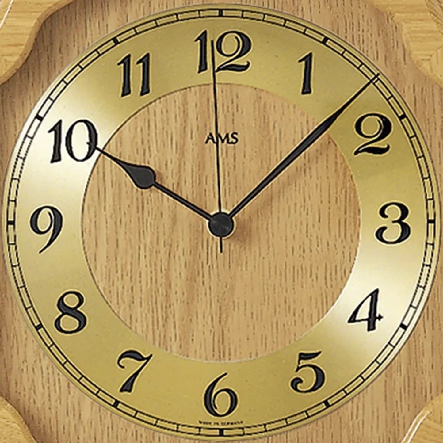 Nahaufnahme der Wanduhr: AMS-Zifferblatt in hellem Holz mit Mineralglas und Zeigern