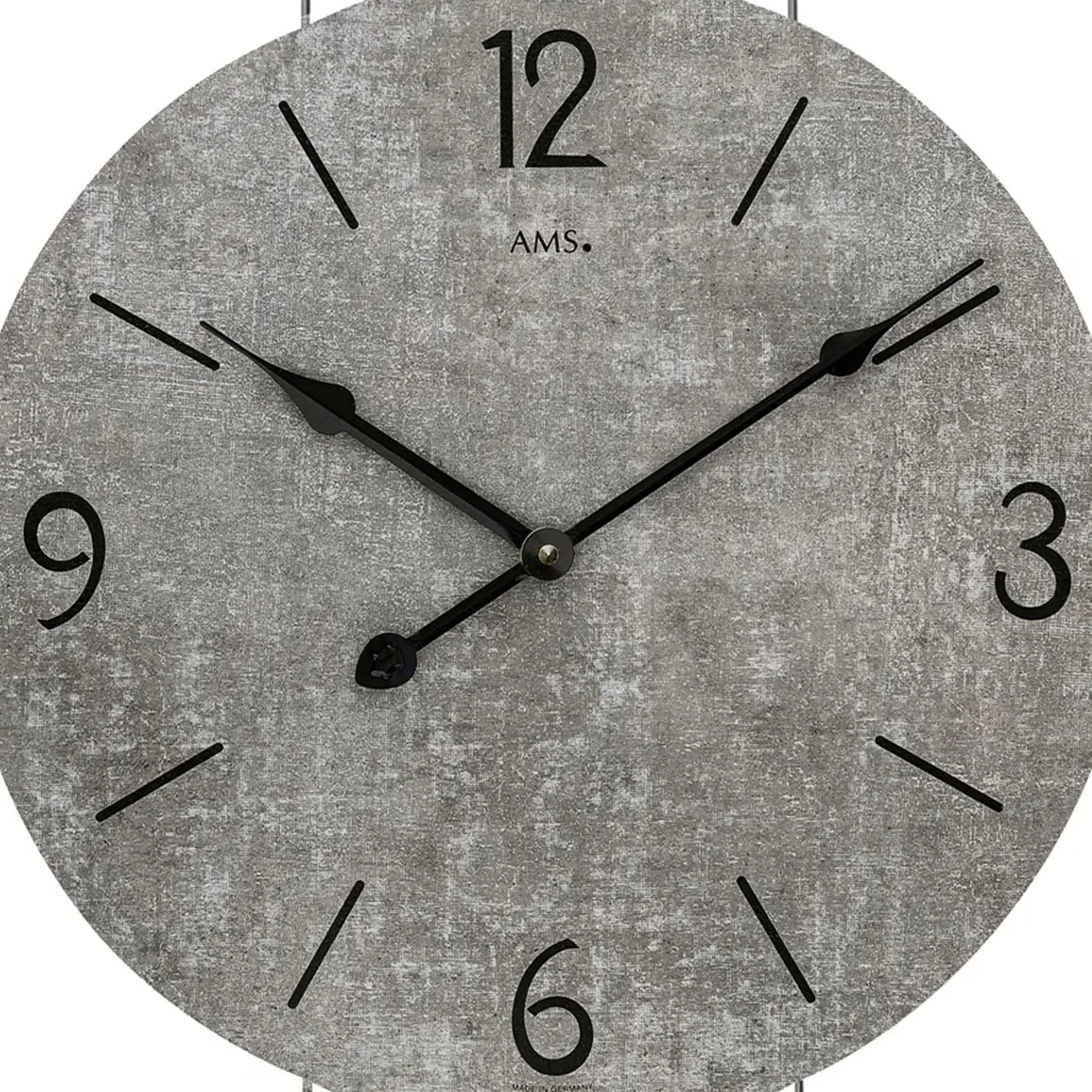 Nahaufnahme der Wanduhr: graues Zifferblatt mit schwarzen Zeigern und Ziffern.