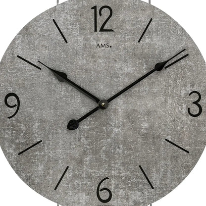 Nahaufnahme der Wanduhr: graues Zifferblatt mit schwarzen Zeigern und Ziffern.