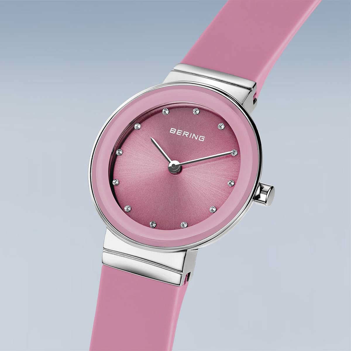 "Damklocka i profil med rosa armband och rund urtavla i roséguld"