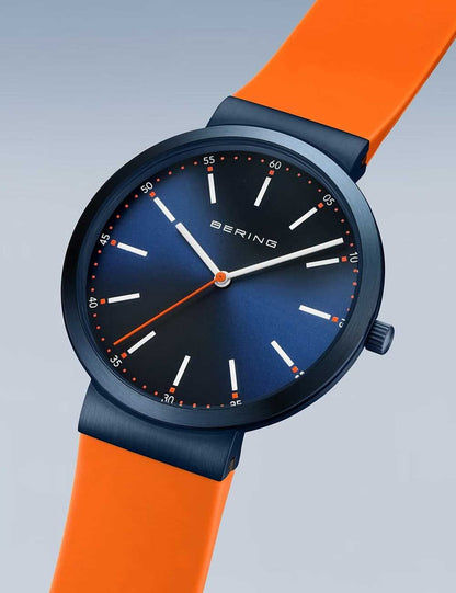 Bering Herrenarmbanduhr mit rundem blauem Zifferblatt, orangefarbenem Silikonarmband