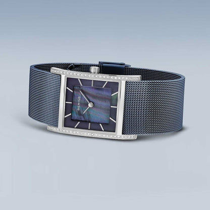 "Damklocka med mörkblått milanesarmband, rektangulärt ur med steninfattning"