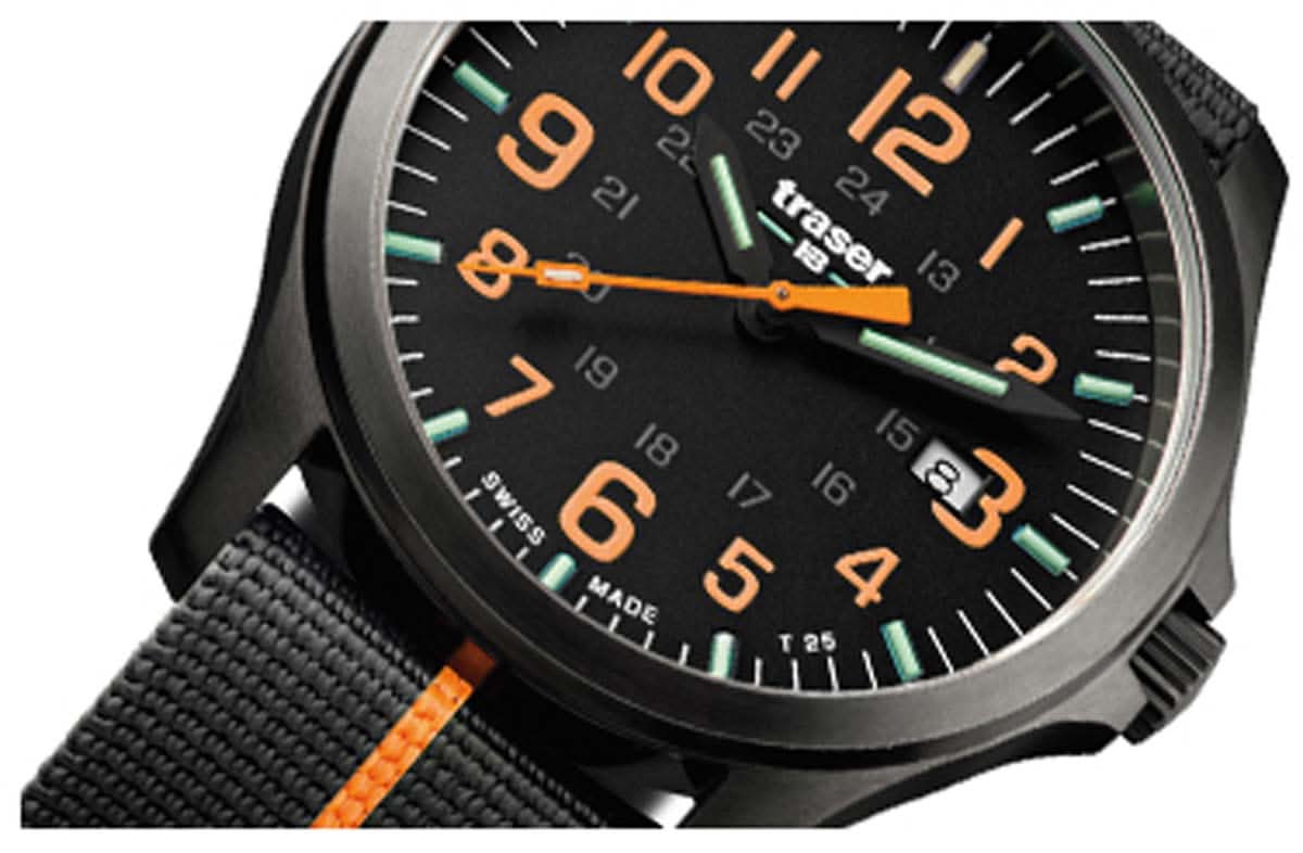 Herrklocka närbild: svart urtavla, orange visare, självlysande gröna index, svart armband