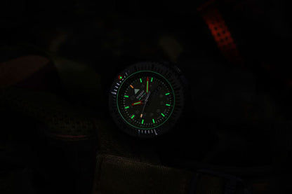 Herrklocka med mörk urtavla och grönt lysande markeringar längs kanten