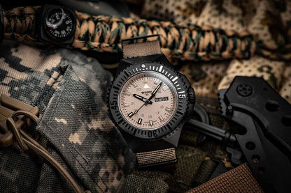 Herrarmbandsur med svart infattning, beige urtavla och beige textilarmband.