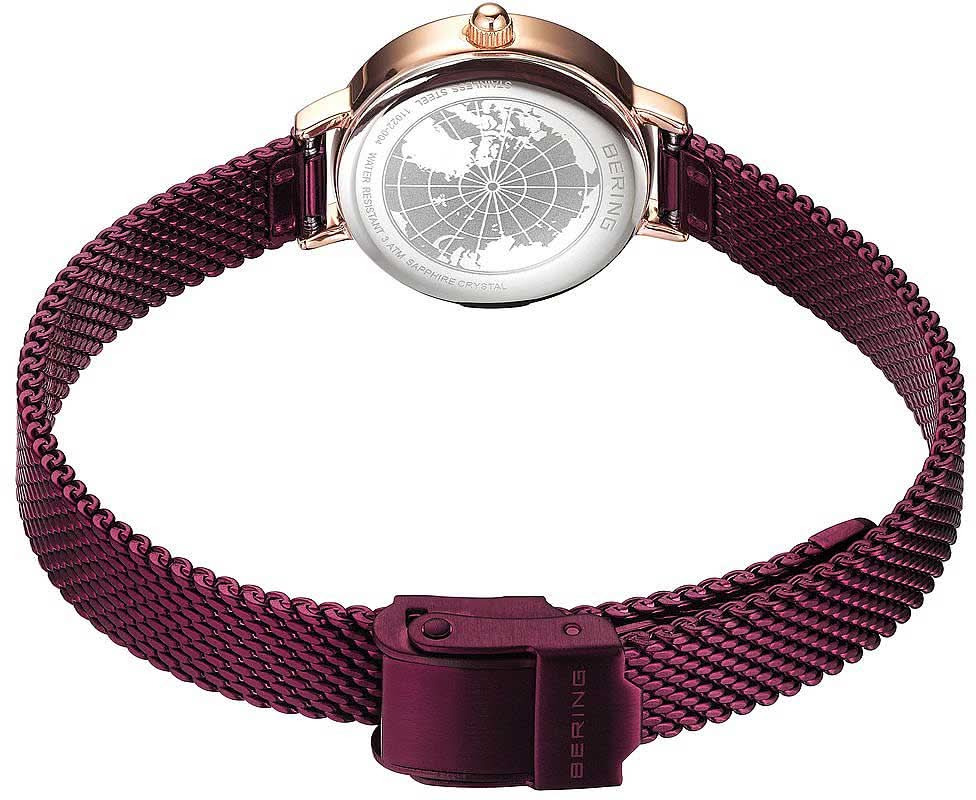 Damklocka med lila metallflätat band, rund boett med gravyr, roséguldigt spänne.