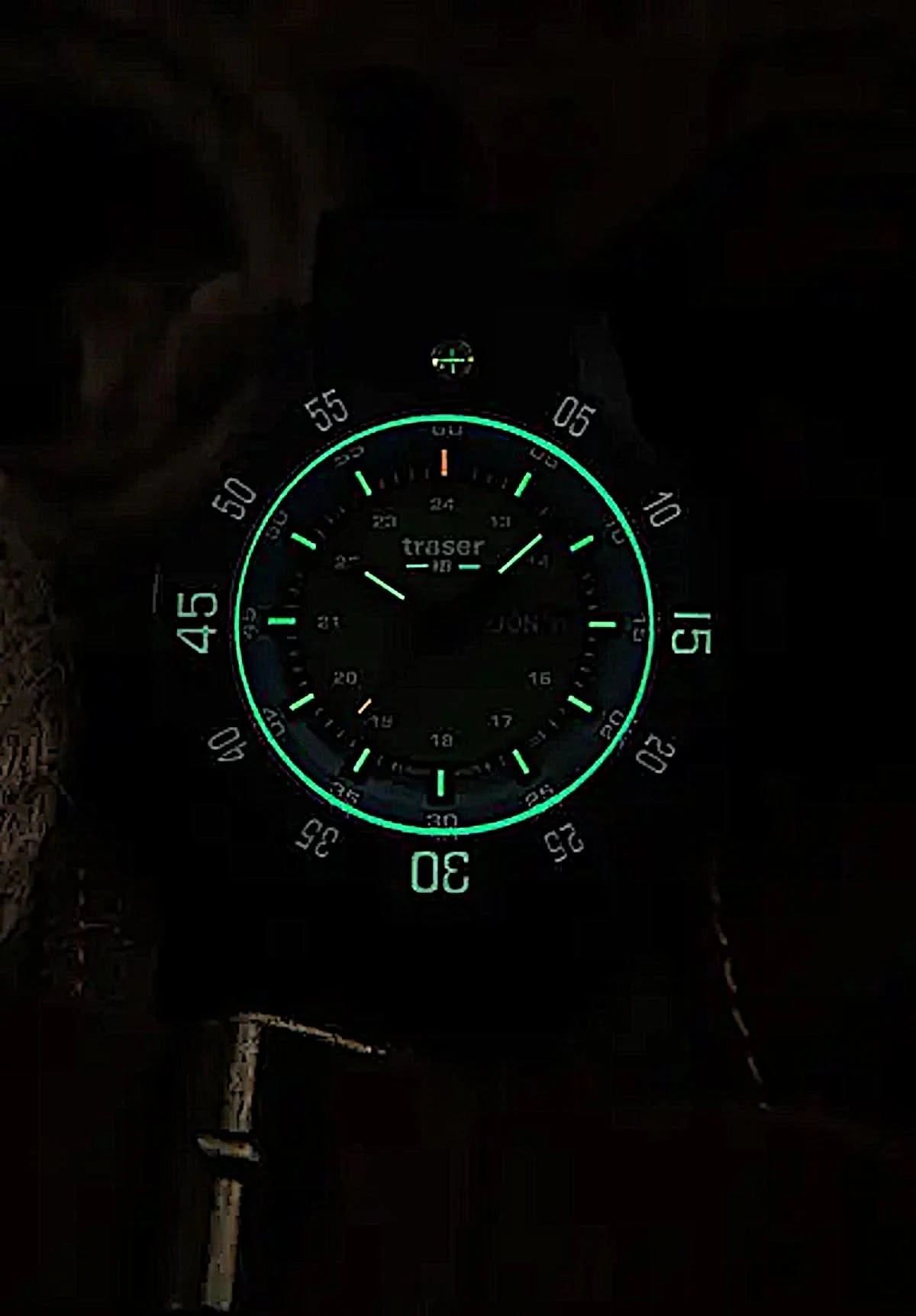 Taktisk klocka med mörk urtavla och självlysande gröna visare, textilarmband