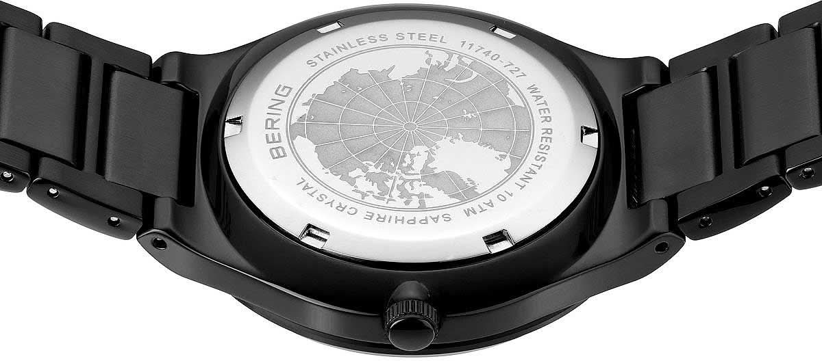 Baksidan av herrklocka med gravyr på boett i svart och metallarmband