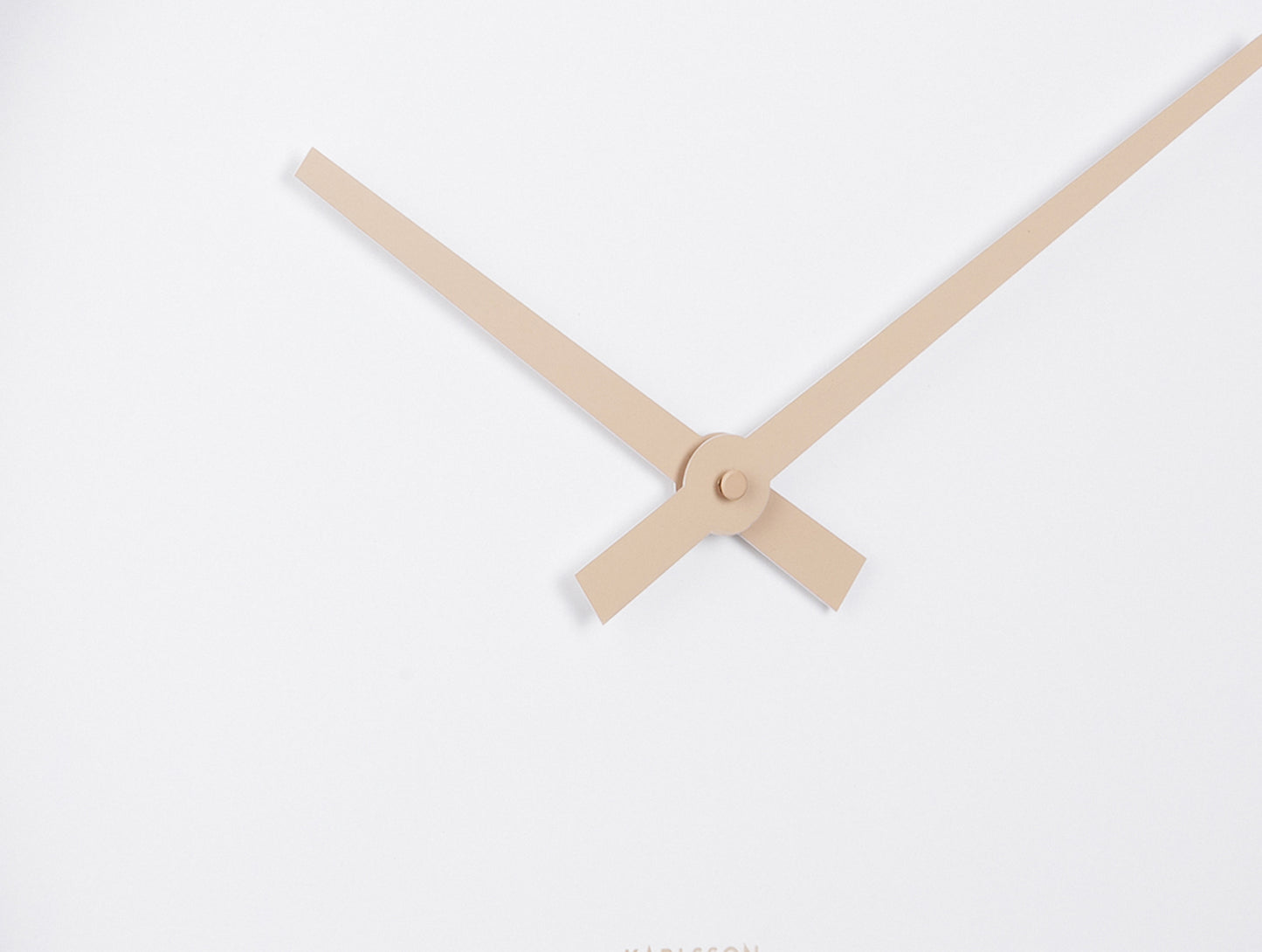 Väggklockemekanik i detalj: beige visare på vit urtavla, rund mitt