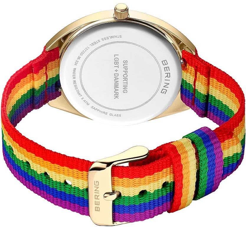 "Damklocka med guldfärgat hölje och regnbågsfärgat armband"