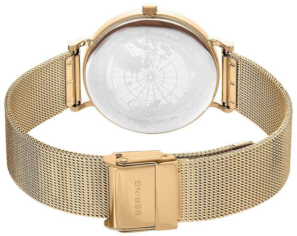 Damklocka med världskartadetalj på baksidan och guldfärgat Milanese-armband