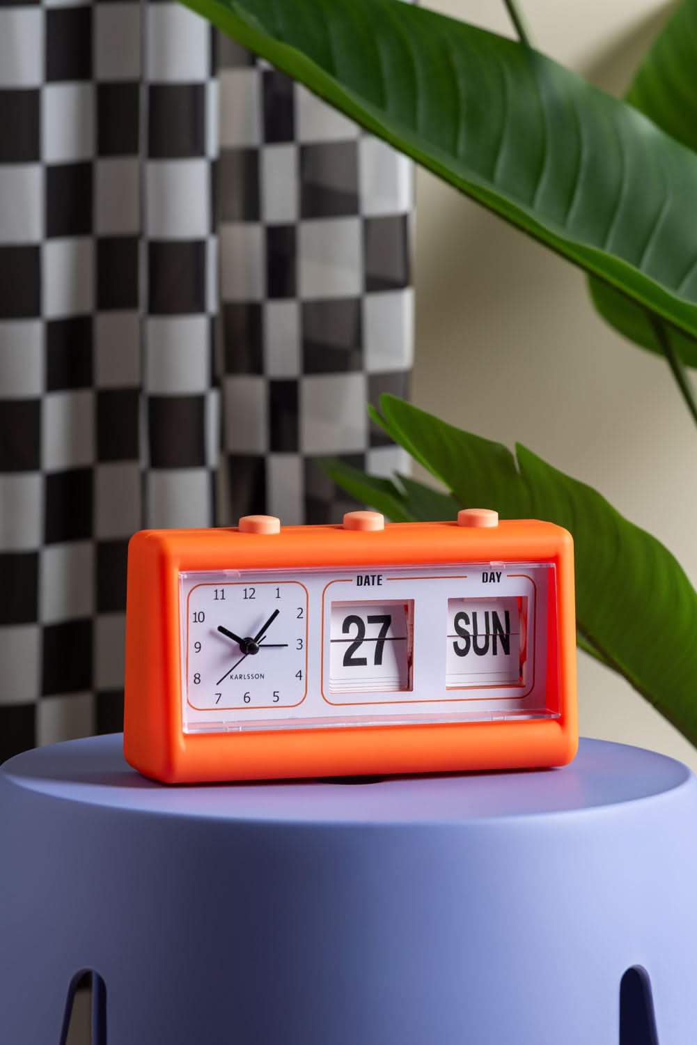 Orange väckarklocka med blädderdisplay, datum 27 och SUN i fönstret