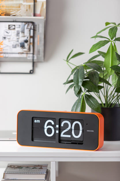 Orange väggklocka med fällbara siffror, dubbel display 6:20, svart front