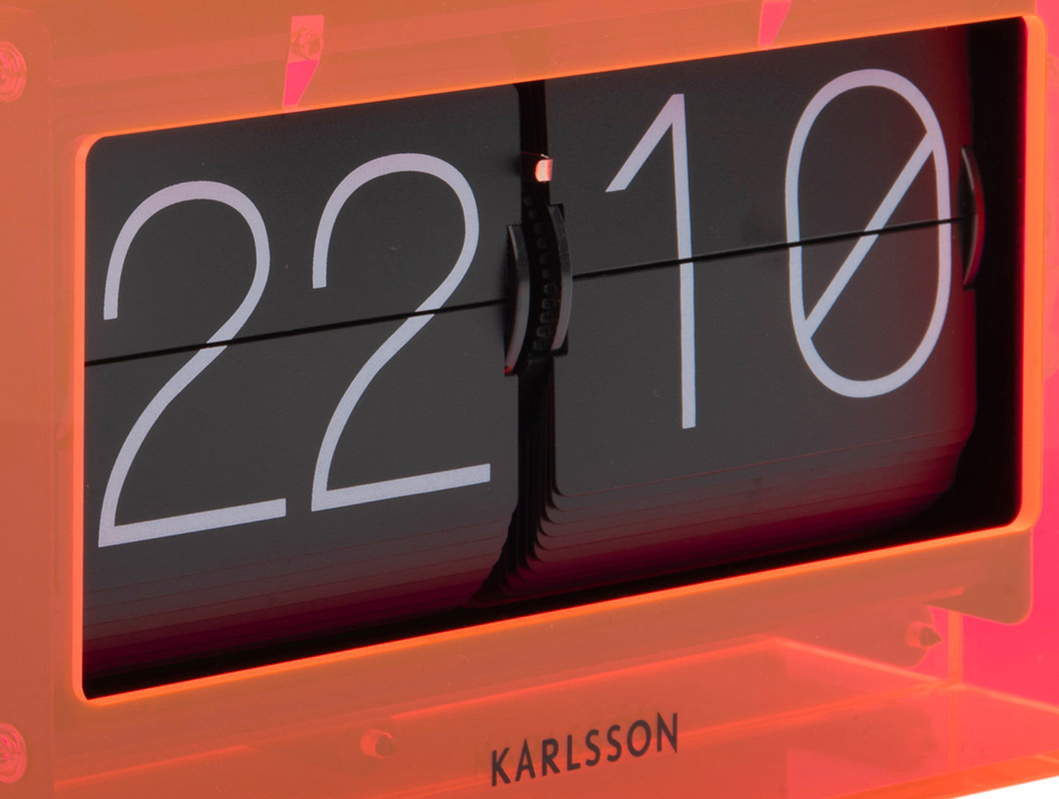 Neonorange bordsklocka med flip-display i akrylhölje, närbild på siffrorna 22 och 10.
