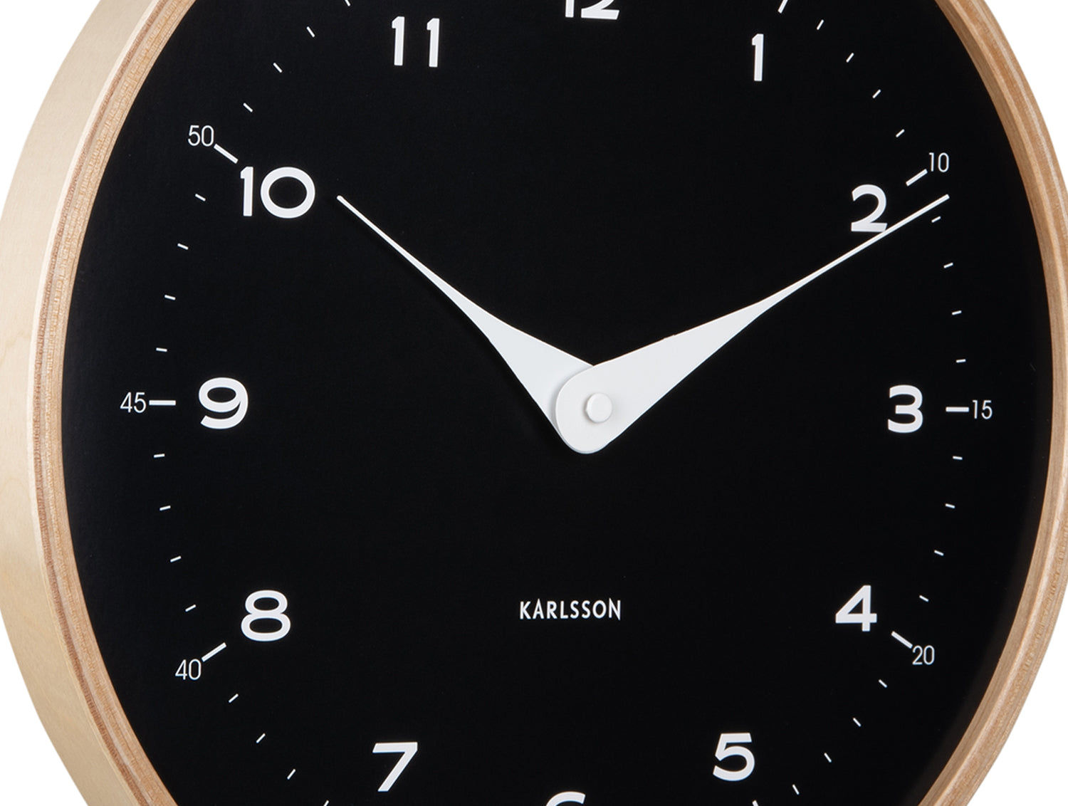 Närbild på en svart väggklocka: träram, visare och siffror