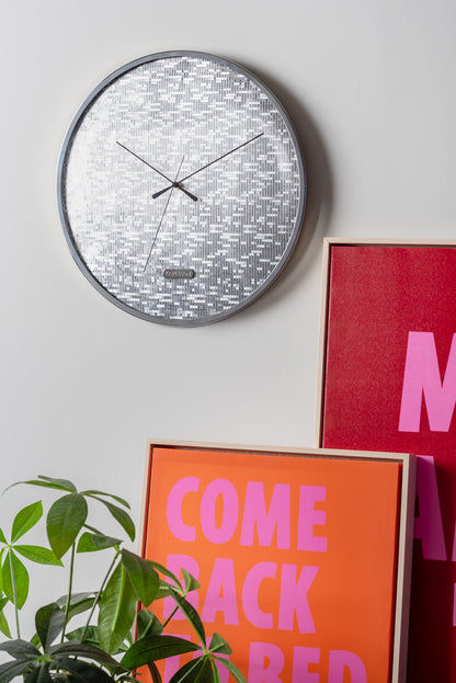 "Silver round wall clock with mosaic dial and black hands"