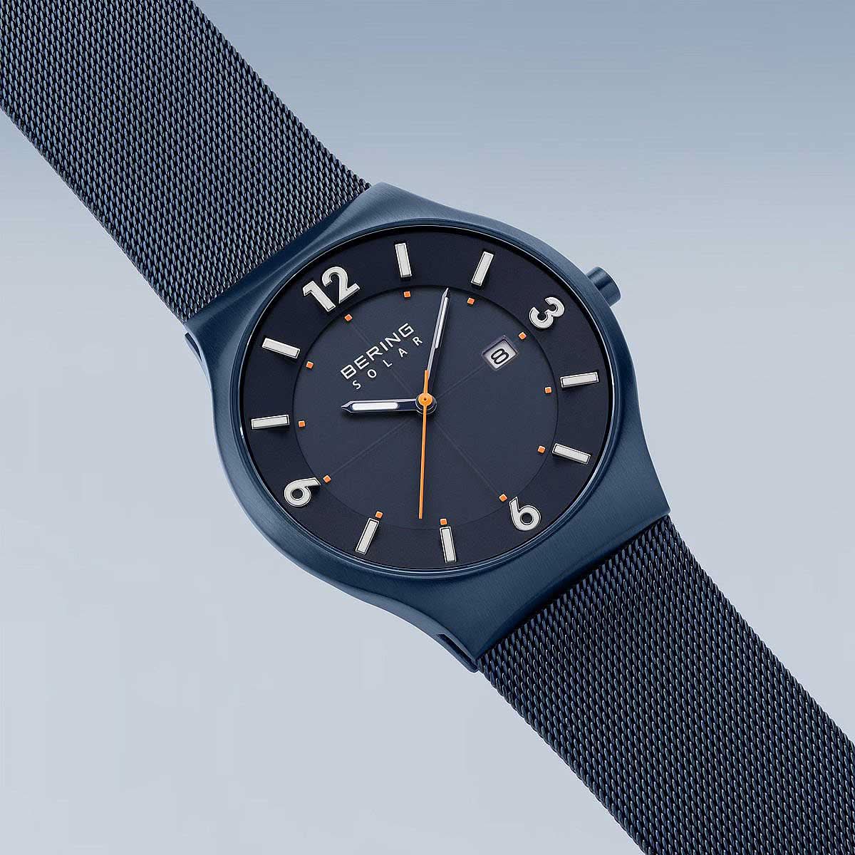 Herrklocka med blå urtavla och mesh-metallarmband, sidovy av urtavlan