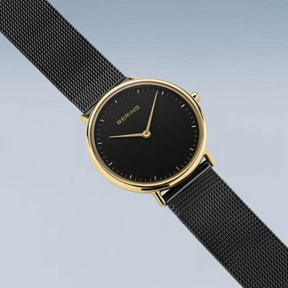"Damklocka Bering med svart urtavla och guldfärgad krona, svart mesh-armband."
