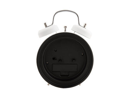Väckarklockans baksida i svart med batterifack, vit ram och stödfötter.