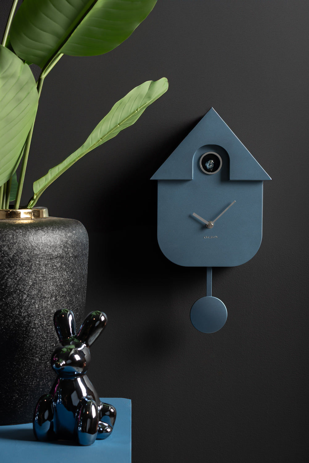 Karlsson Gökur väggklocka mörkblå husdesign med pendel och logotyp nedtill