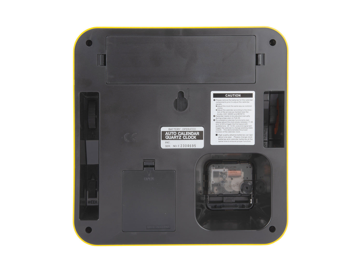 Baksidan av den gula väggklockan med batterifack och klistermärke