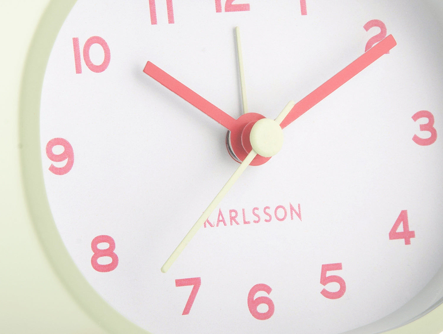 Oval väckarklocka från Karlsson: röda tim- och minutvisare, ljus urtavla, logotyp