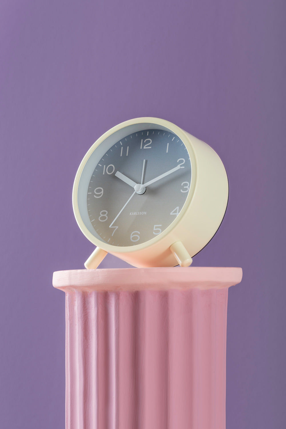 Gradient-väckarklocka på rosa pelare, runt gult hölje med urtavla