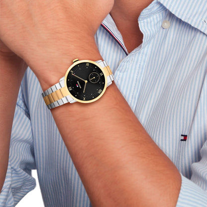 Tommy Hilfiger Herrenuhr mit schwarzem Zifferblatt und zweifarbigem Armband am Handgelenk