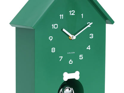 Grön väggklocka i hundkojedesign, detalj av visare och ben