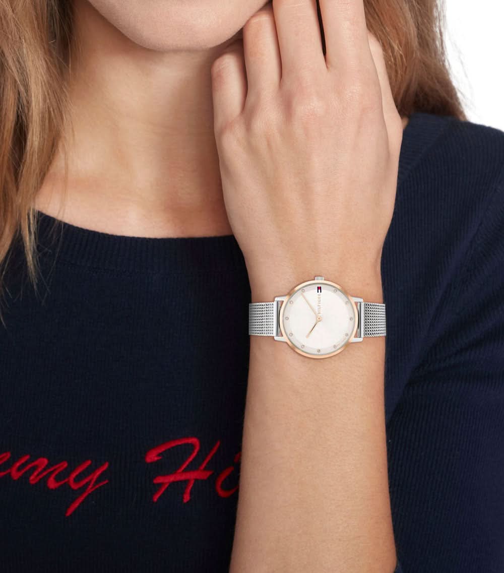 Armbandsur för dam på handleden med silverfärgat mesharmband och ljus urtavla