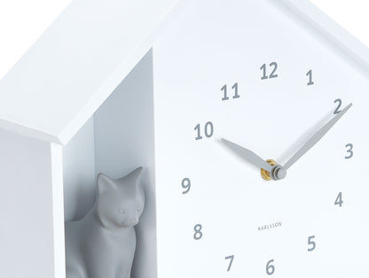 Väggklocka i kattens hus, vit, närbild av katt och visare