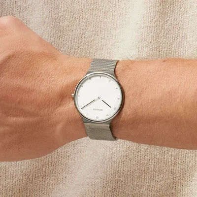 Damenuhr am Handgelenk mit silbernem Milanaise-Armband und weißem Zifferblatt