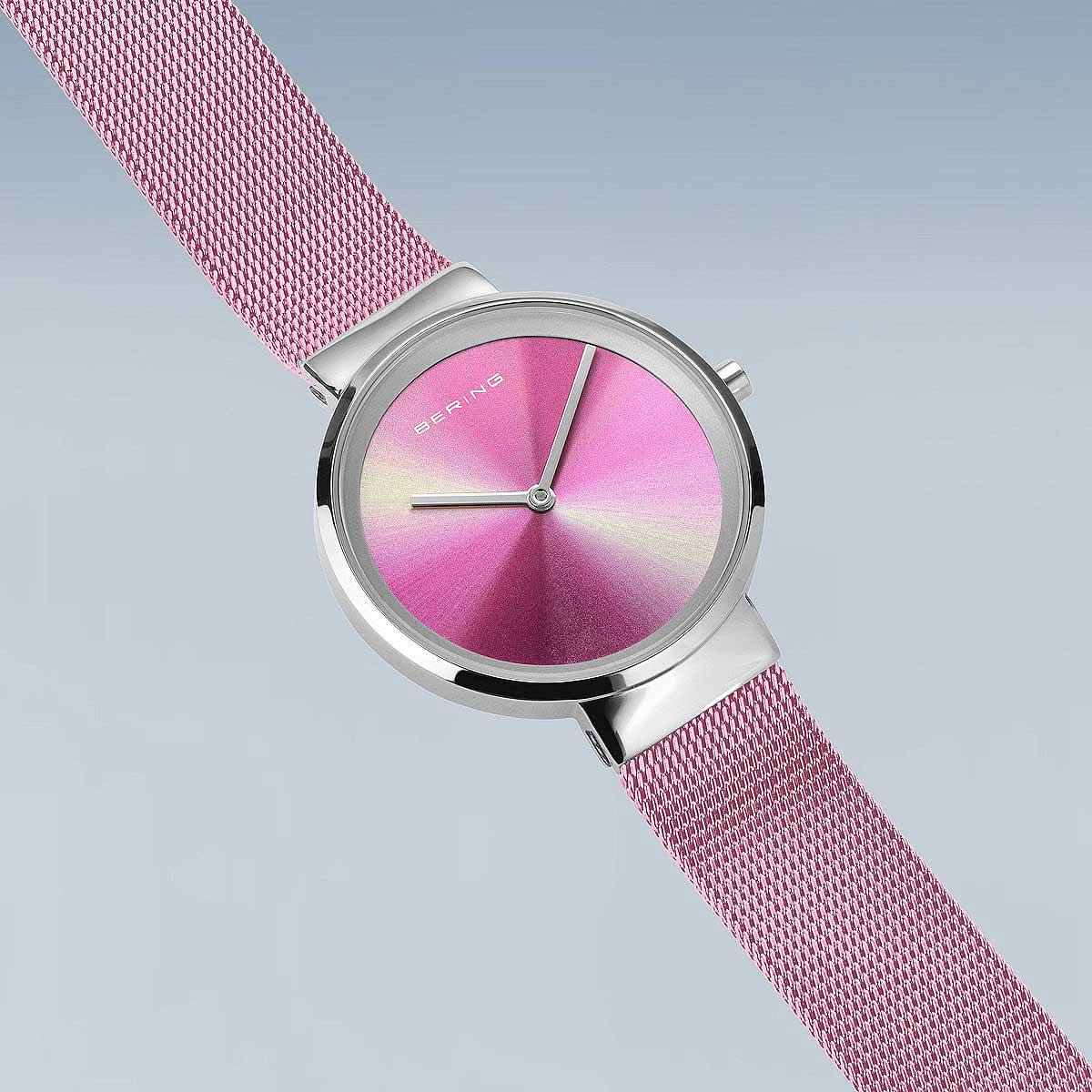 Bering damklocka på handleden med rosafärgat Milanese-armband och rund, rosa urtavla