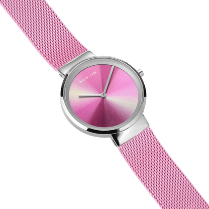 "Damklocka med rosafärgat milanesarmband, rund rosa urtavla och silverfärgade visare"