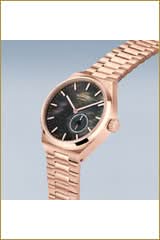 "Damklocka med roséguldpläterat metallarmband och rund svart urtavla"