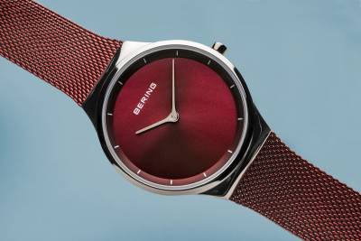 Bering Damenarmbanduhr Close-up: rotes Zifferblatt, silberner Lünette und Milanaiseband