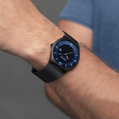 Herrenarmbanduhr am Handgelenk mit dunkelblauem Zifferblatt und schwarzem Mesh-Armband