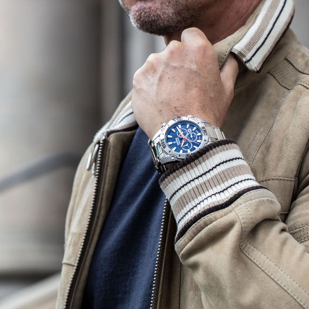 Kronograf för herr på handleden, blå urtavla och metallarmband.