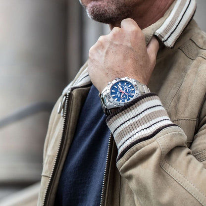 Kronograf för herr på handleden, blå urtavla och metallarmband.