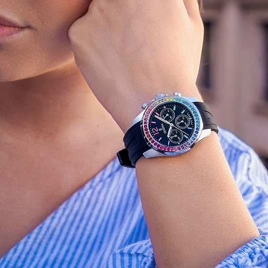 Festina damklocka på handleden, blåskimrande safirglas, svart urtavla, svart armband.