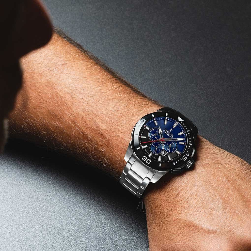 Chronograf på handleden med blå urtavla och armband i rostfritt stål