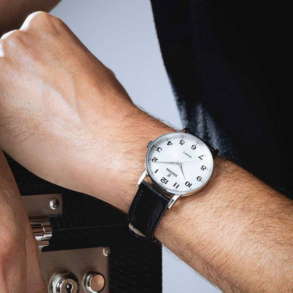 Festina herrklocka på handleden med svart läderarmband och vit urtavla