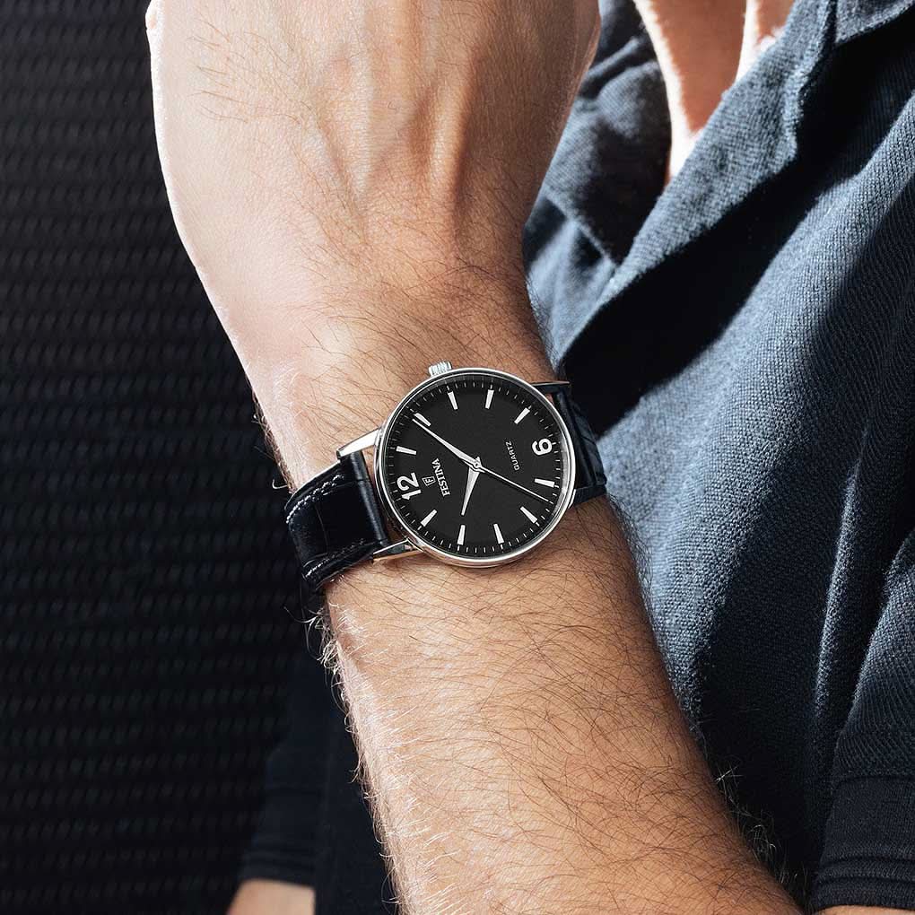 "Festina herrklocka på handleden, svart urtavla och svart läderarmband"