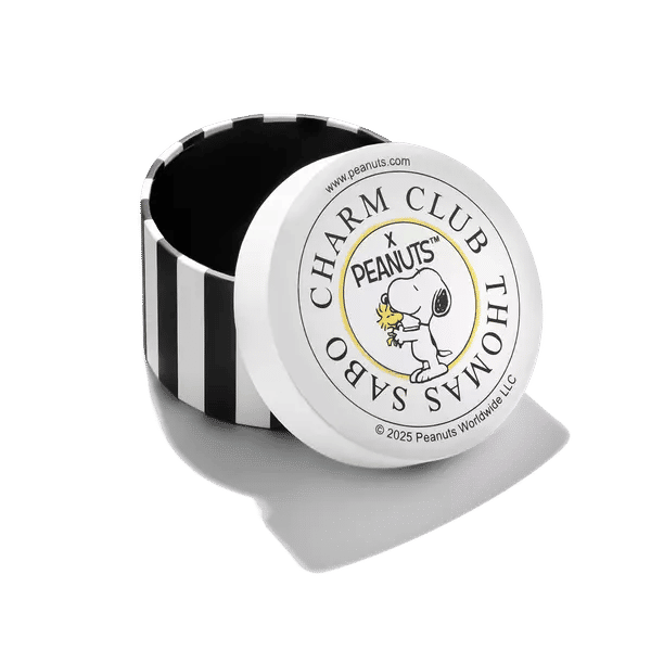 Runt berlock med Peanuts-logotyp, texten "Charm Club" och Snoopy-grafik