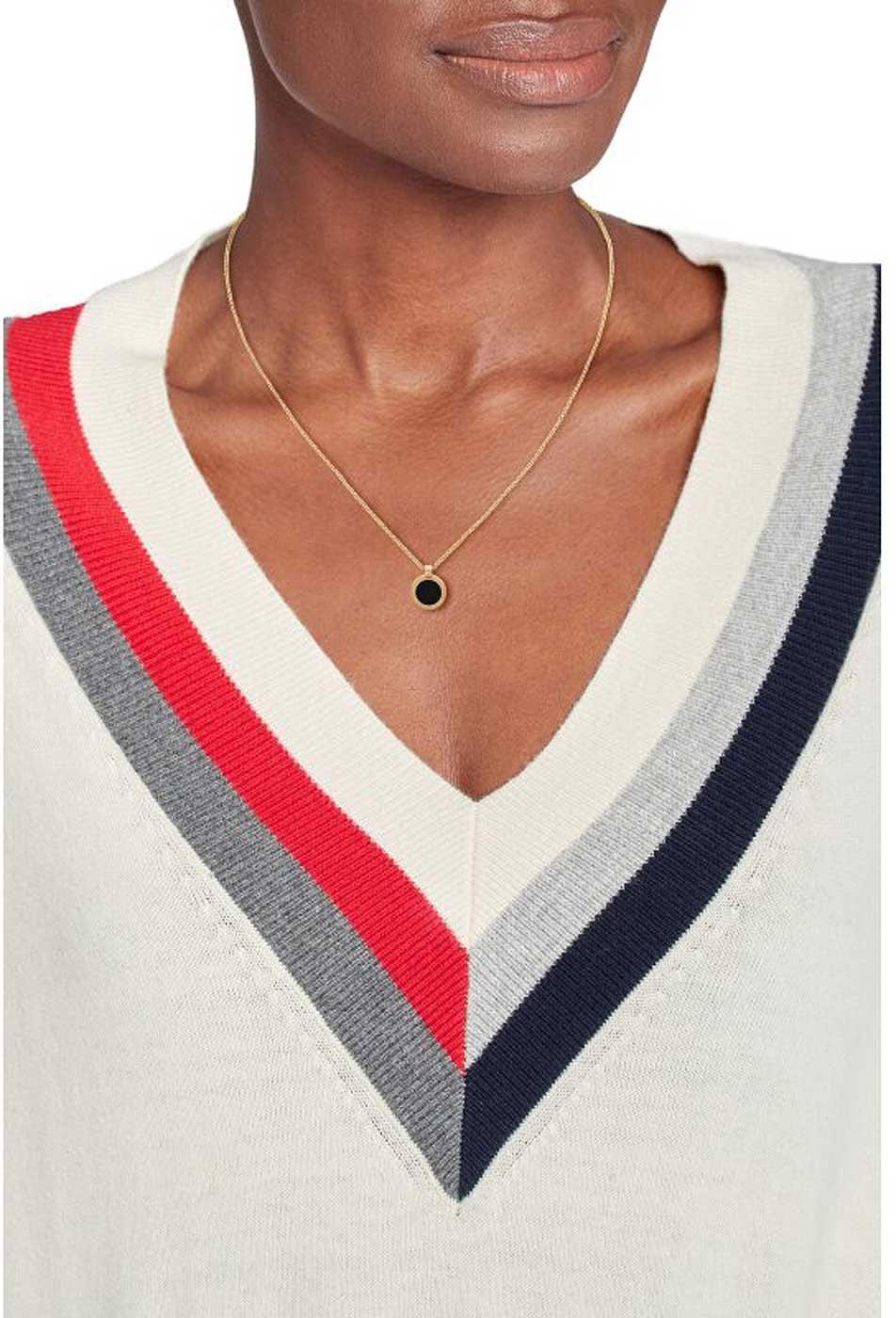 Gyllene halsband på halsen med ett litet runt hänge och en svart cirkel-pendant