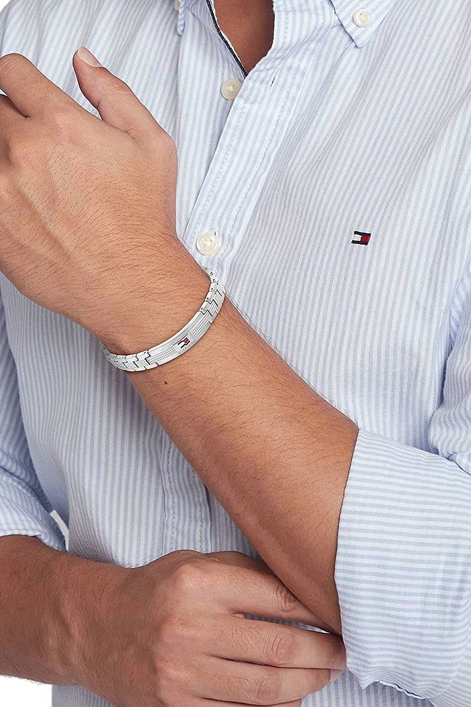 På handleden: Länkarmband i rostfritt stål med Tommy Hilfiger-prägling, silverfärgade länkar