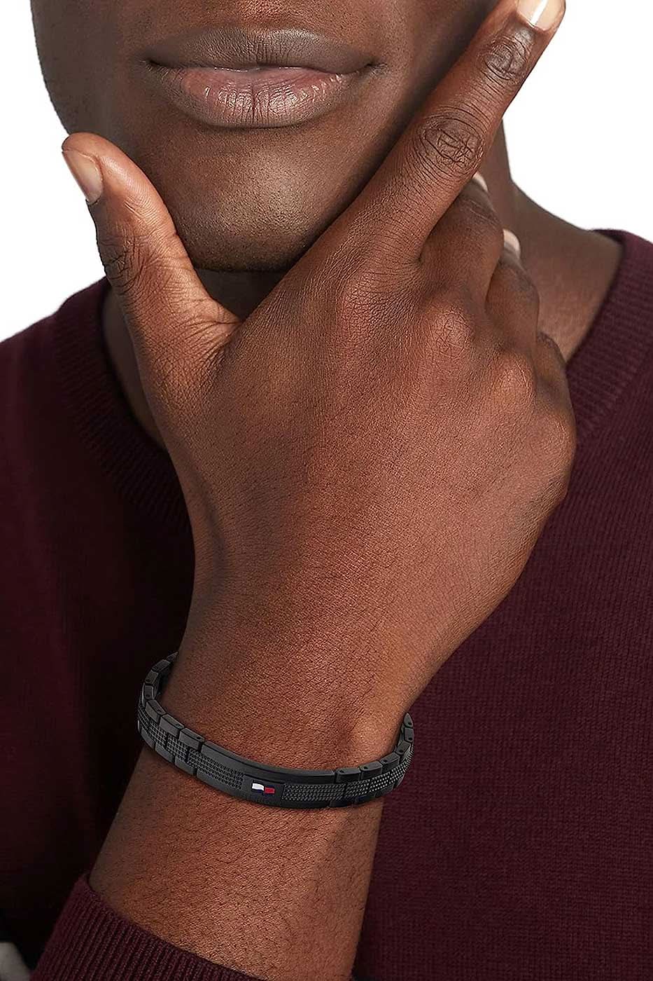 Gliederarmband von Tommy Hilfiger på handleden, svart med struktur och röda accenter